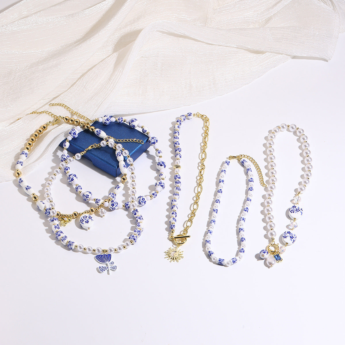 Ceramic flower and pearl necklace collection flat lay